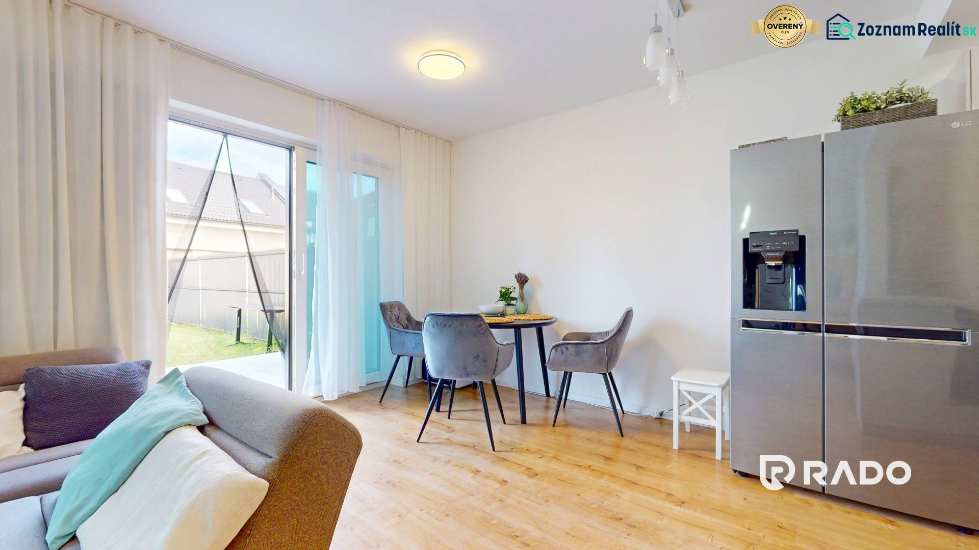 Interior of a 5 or more bedroom apartment with a dining table, sofa, and large refrigerator.