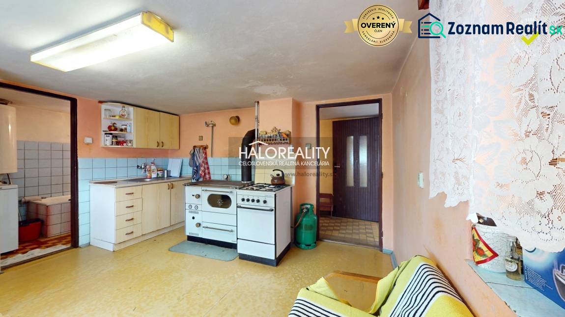 Living room in a cabin with simple furniture, a television, and floral decorations.