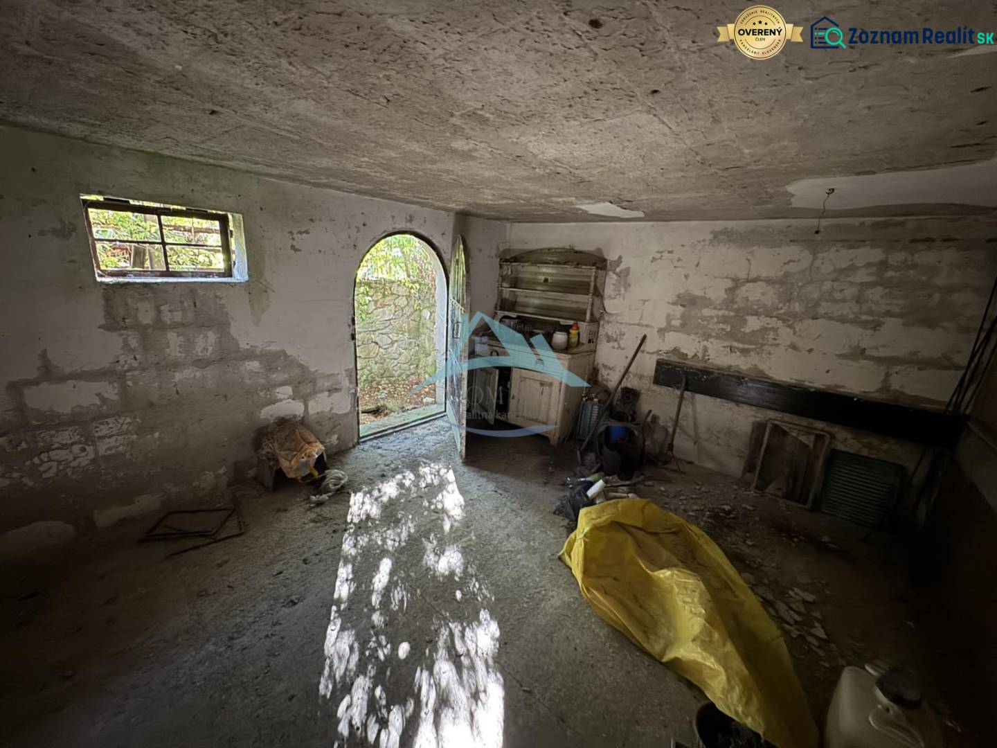 A spacious room with open doors, concrete walls, and diffused natural light in the Cabin.