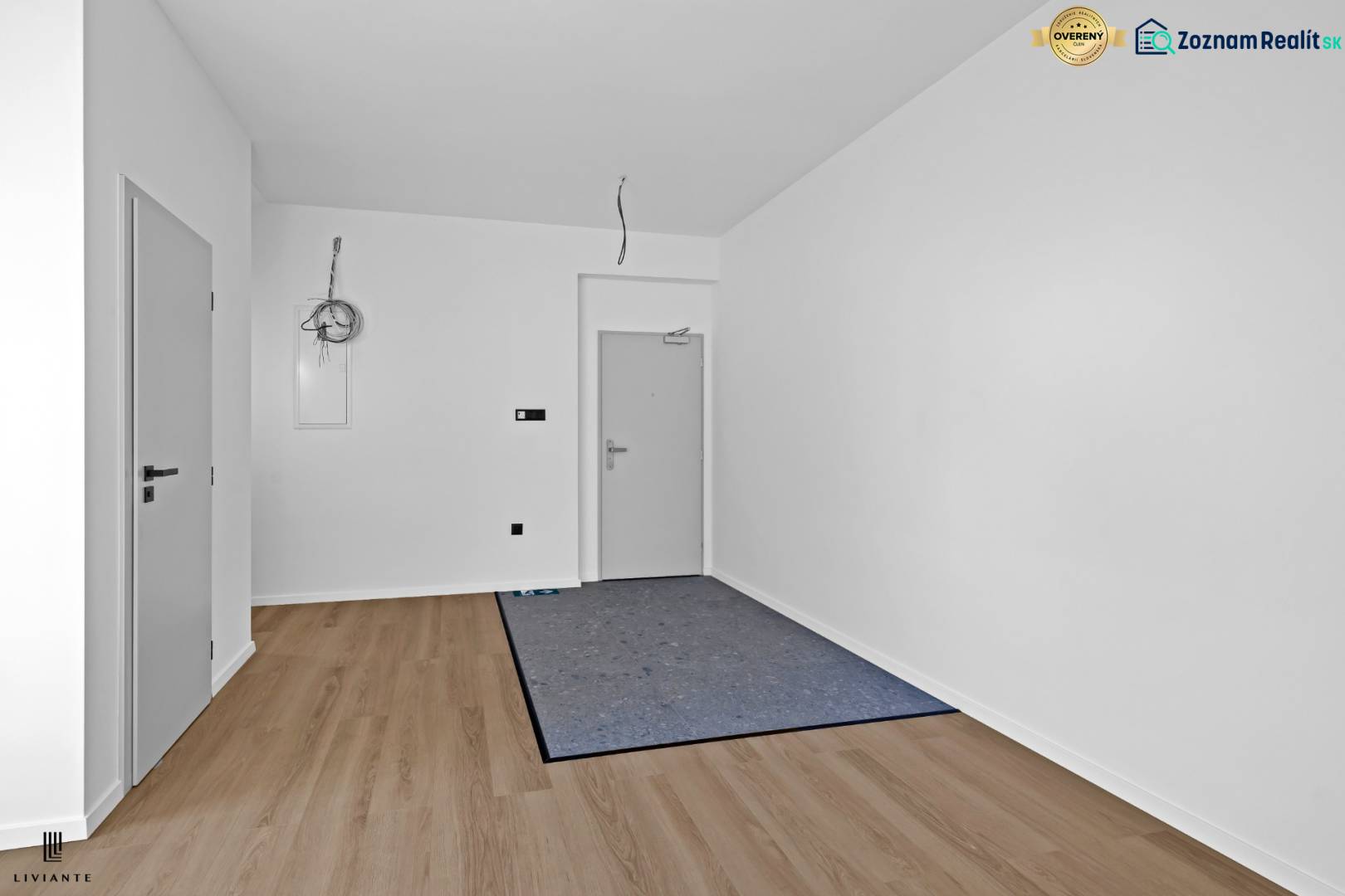 A hallway in a 3-room apartment with a wooden decor floor and white walls.