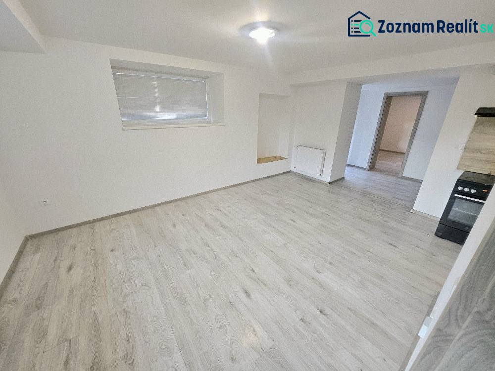 Living room of a three-room apartment with a wooden decor floor and an electric stove.