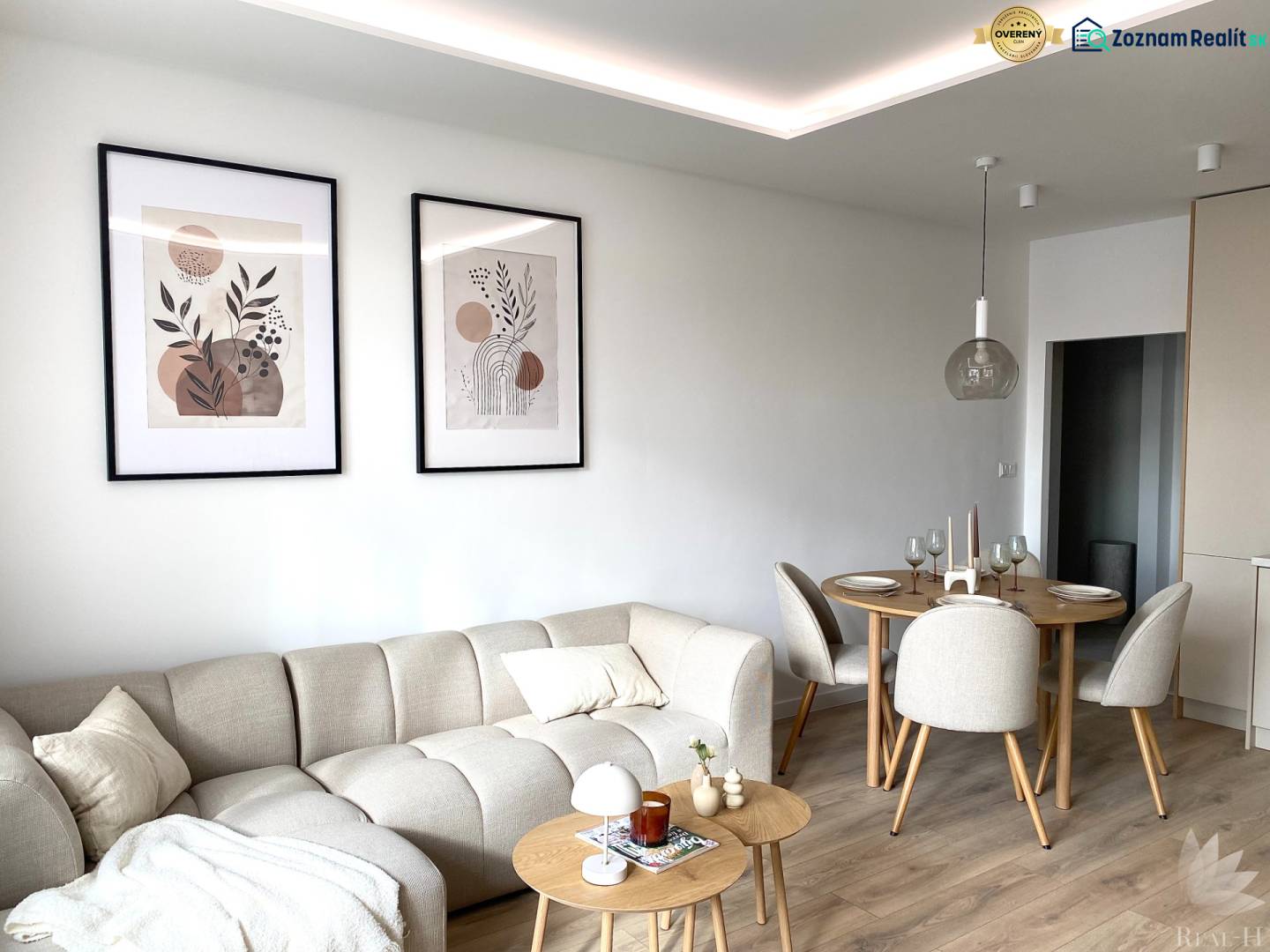 Living room in a 4-room apartment with a sofa and a dining table, wooden decor flooring.