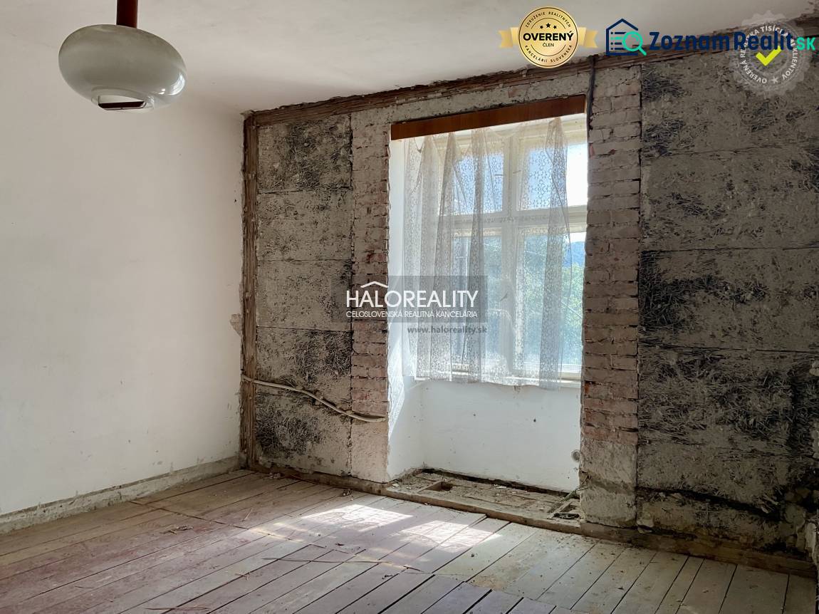 A room with exposed brick and a wood-patterned floor in a family house.