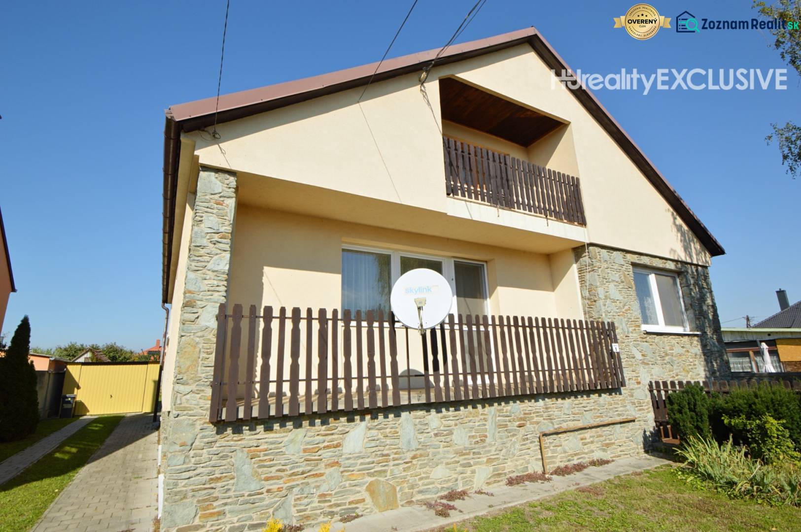 A family house in Hegyeshalom with a balcony, satellite, and stone cladding on the facade.