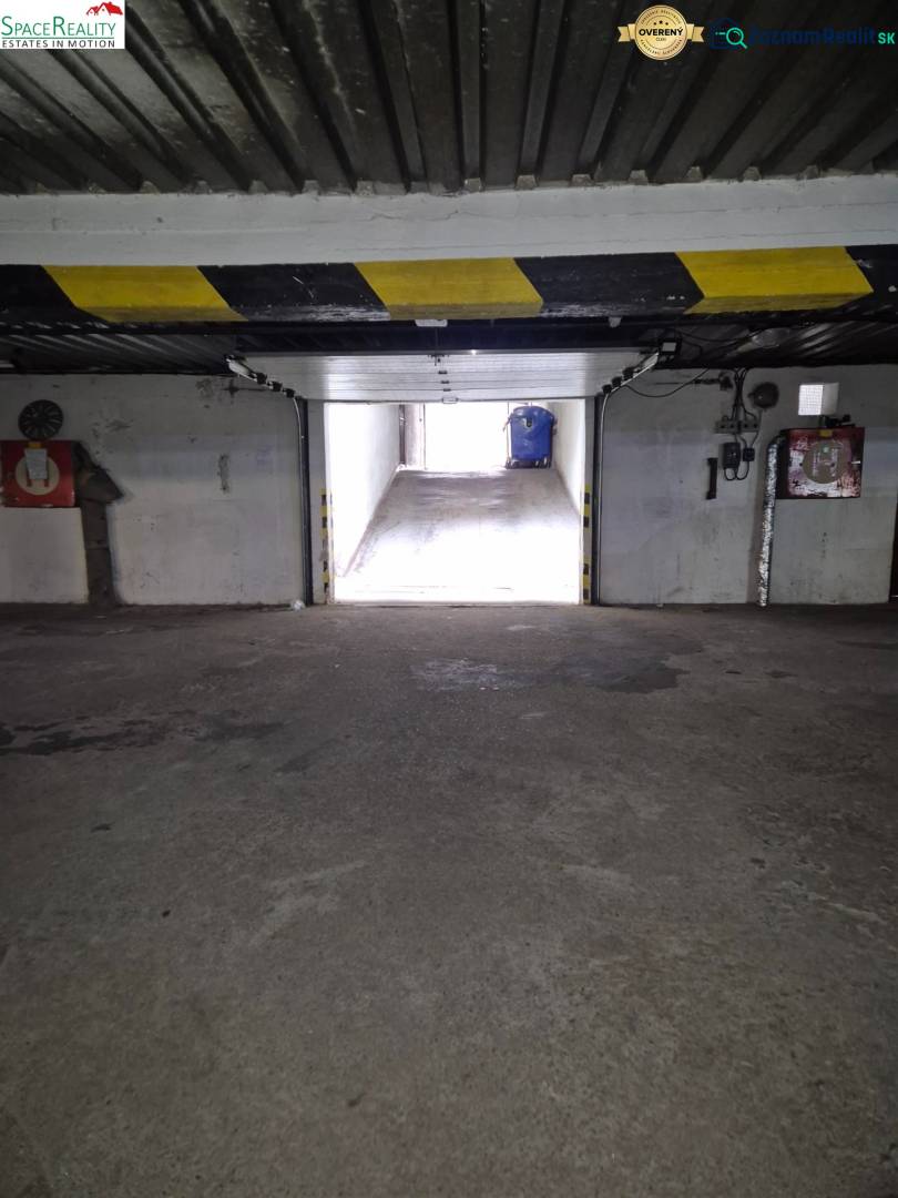 Interior of a garage with an exit, stone-patterned floor, light on Medená in Bratislava.