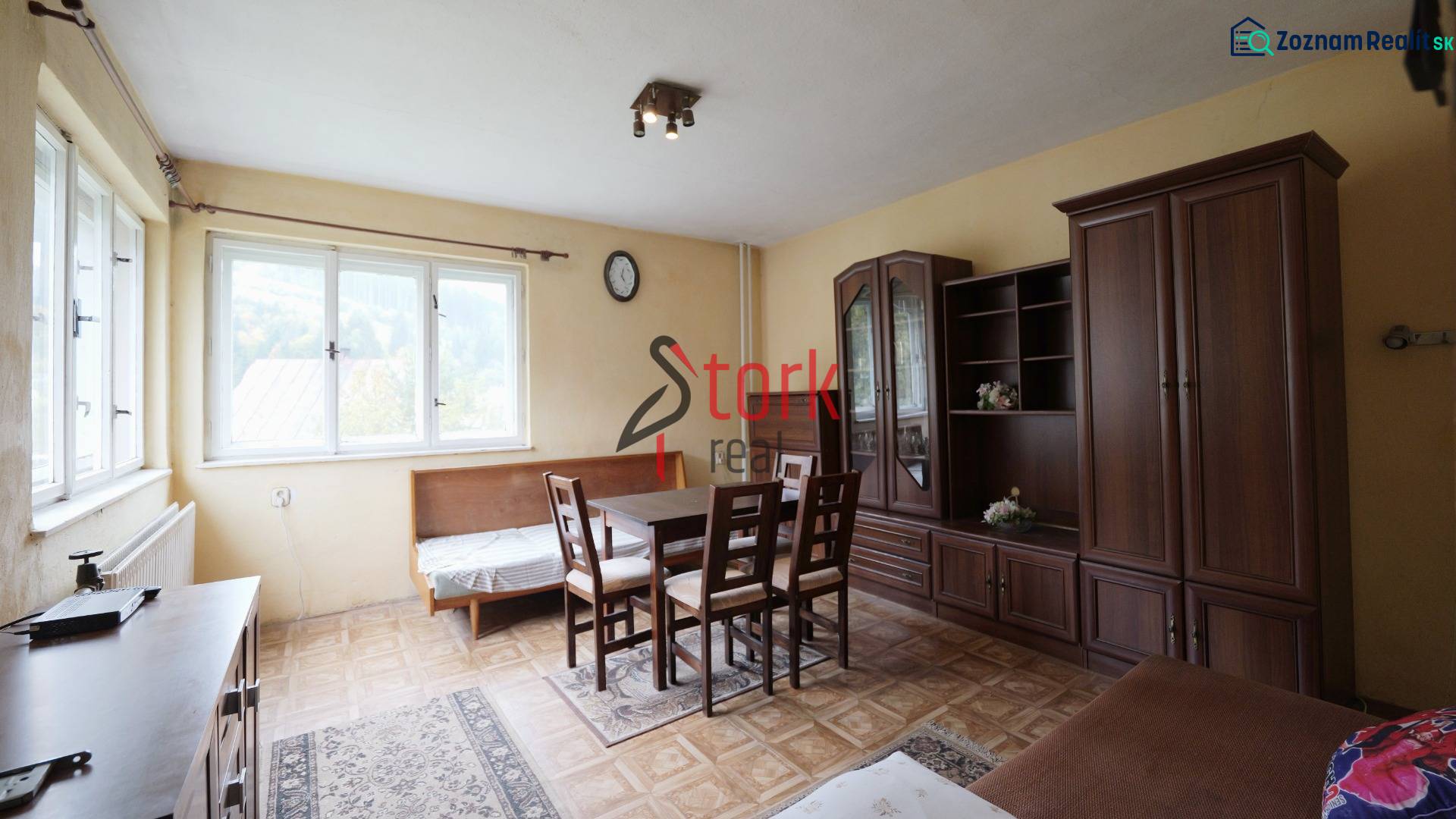 A living room in a family house with light furniture and a wooden decor floor.