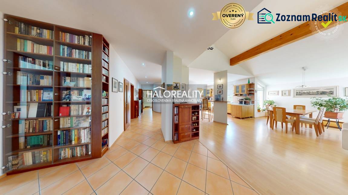 Spacious interior of a family house with a library, dining room, and wooden decor flooring.