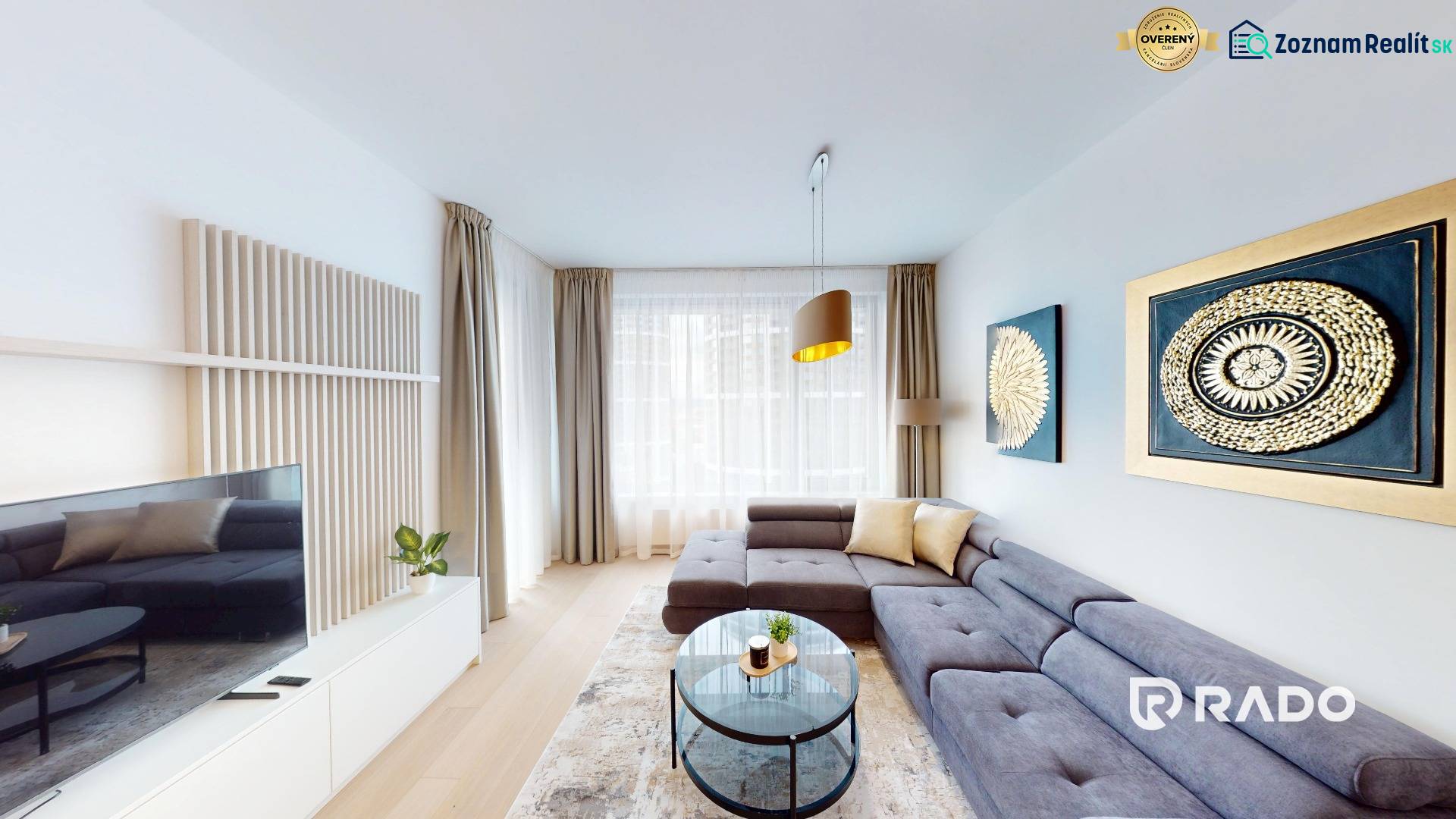 Bright living space in a two-room apartment with wooden decor flooring and wall paintings.