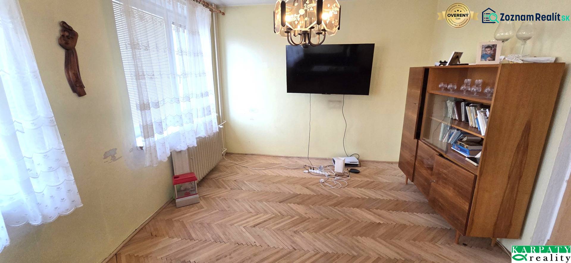 Living room with a TV, display cabinet, and wooden decor flooring in a 3-room apartment.