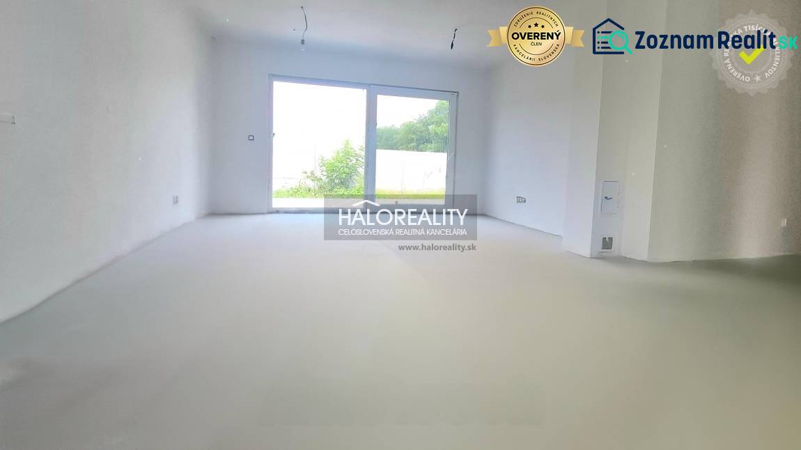 A spacious room with a large window in a family house, white walls, view of the garden.