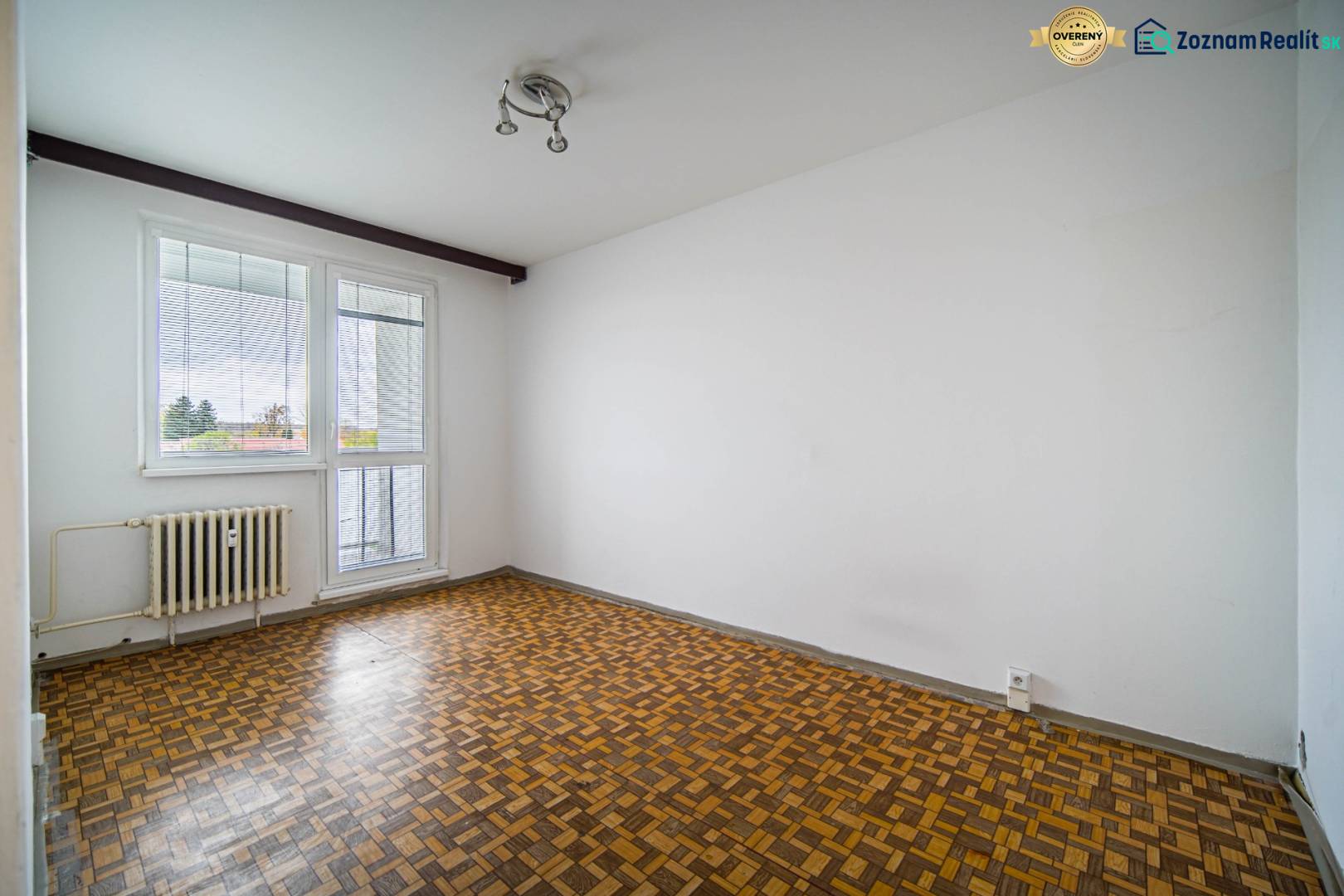 An empty room with a wood-patterned floor in a 3-room apartment.
