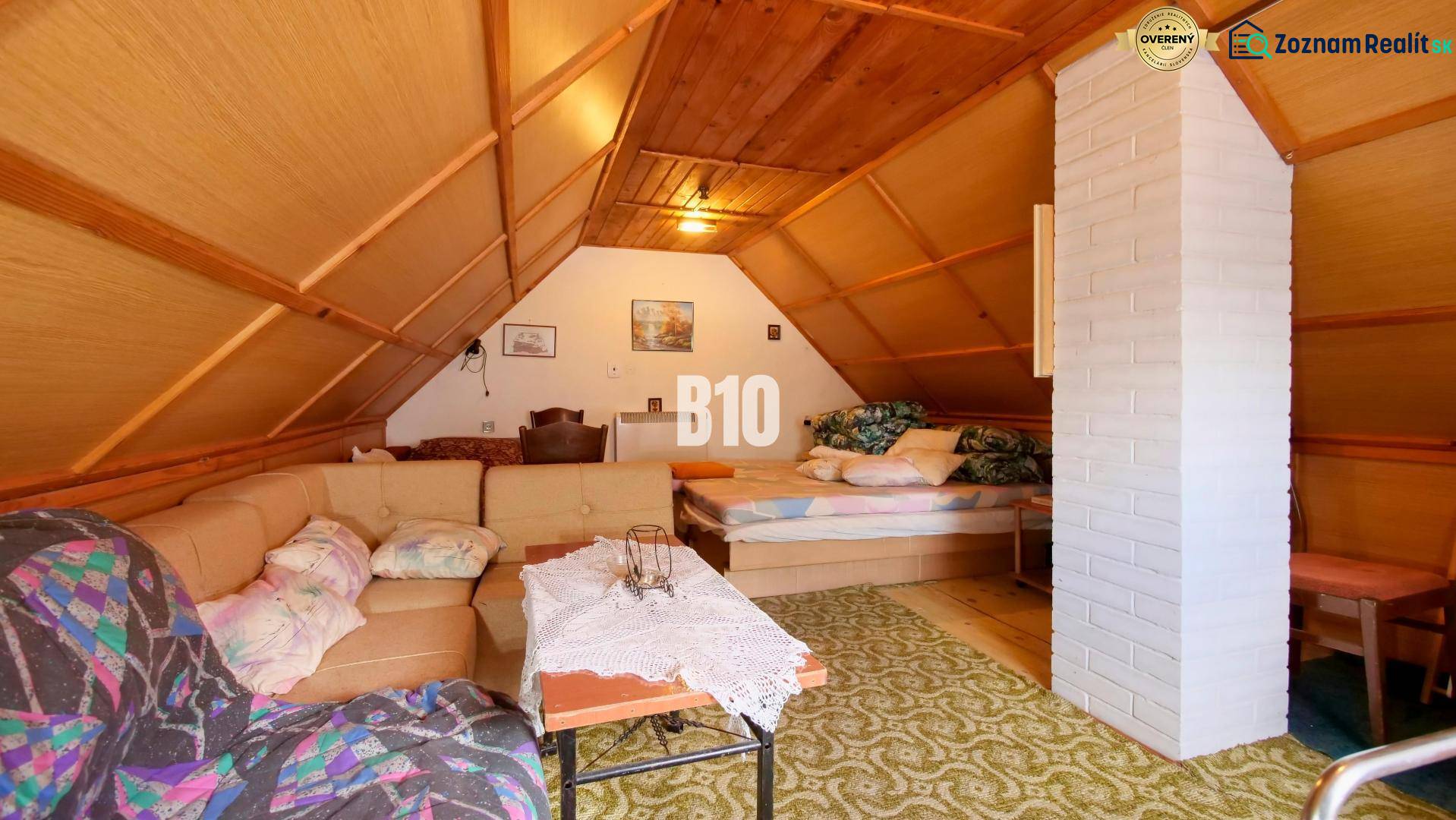 The attic of the cottage with a sofa, fireplace, and bed. A peaceful atmosphere for relaxation.