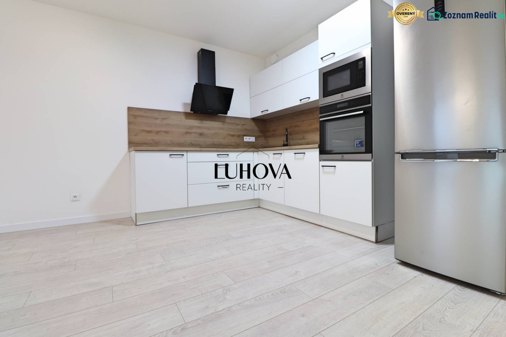 A kitchen with built-in appliances and a wooden decor floor in a 4-room apartment.