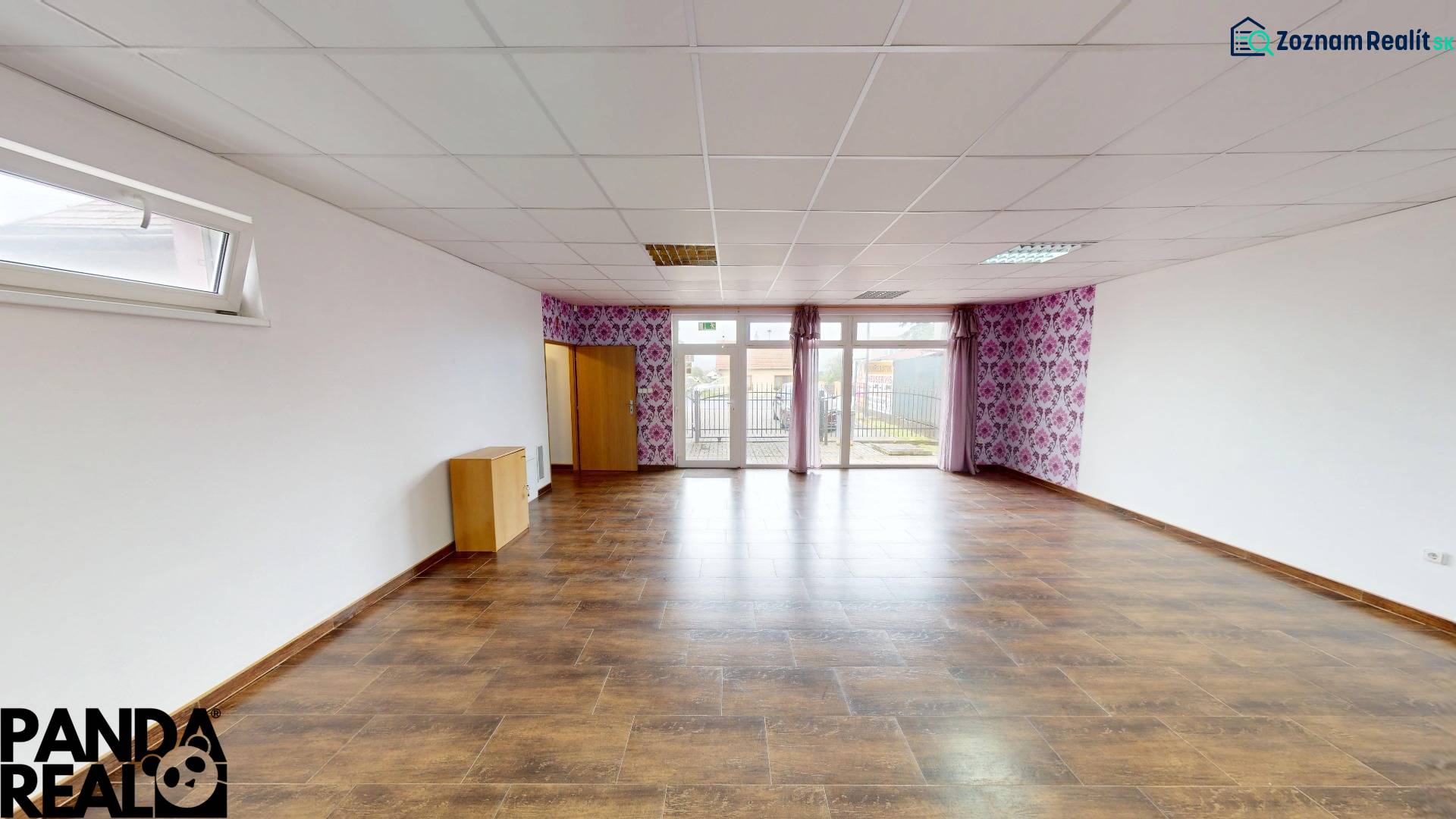 A spacious room in a family house with a wooden decor floor and wallpaper.