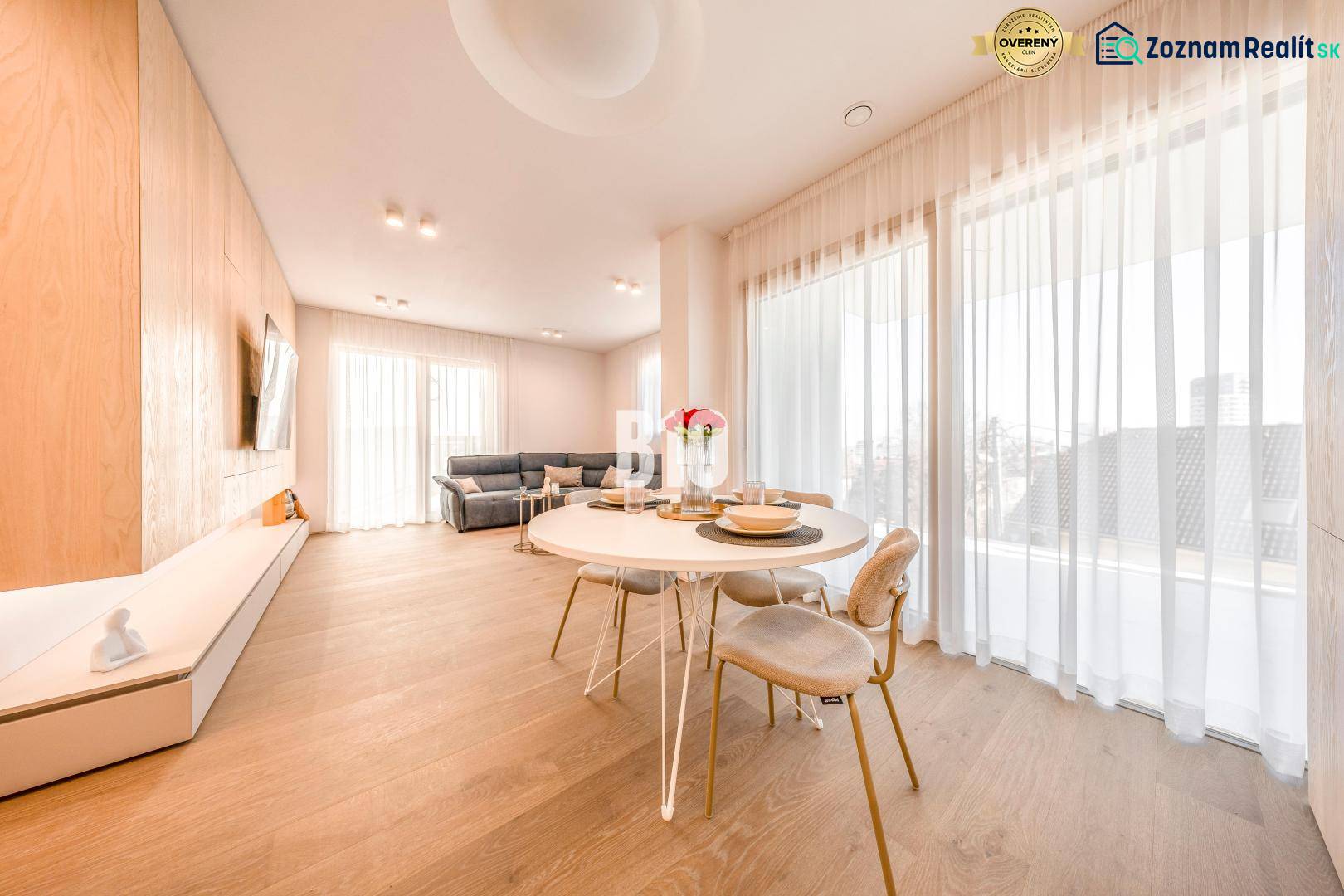 Living room in a 3-room apartment with a wood-patterned floor, dining table, and sofa.