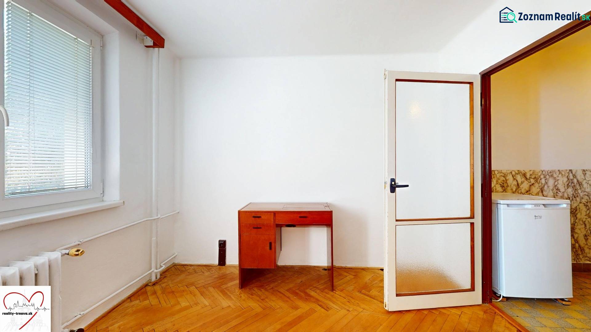 A room with a wooden floor decor, a table, and doors in a 3-room apartment.