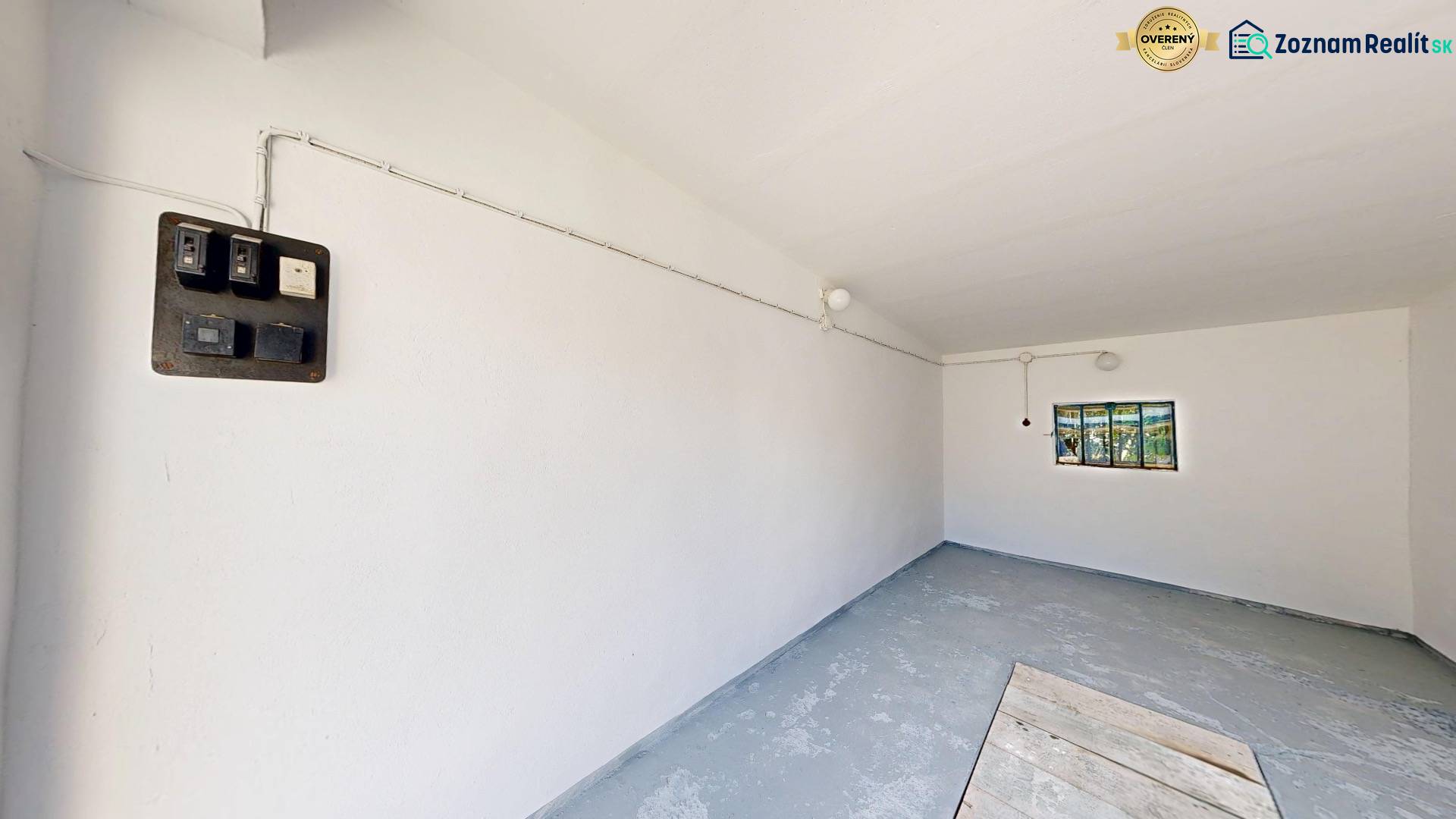 White garage with a window and an electrical panel, Holíč, Akademika Jozefa Čabelku Street.