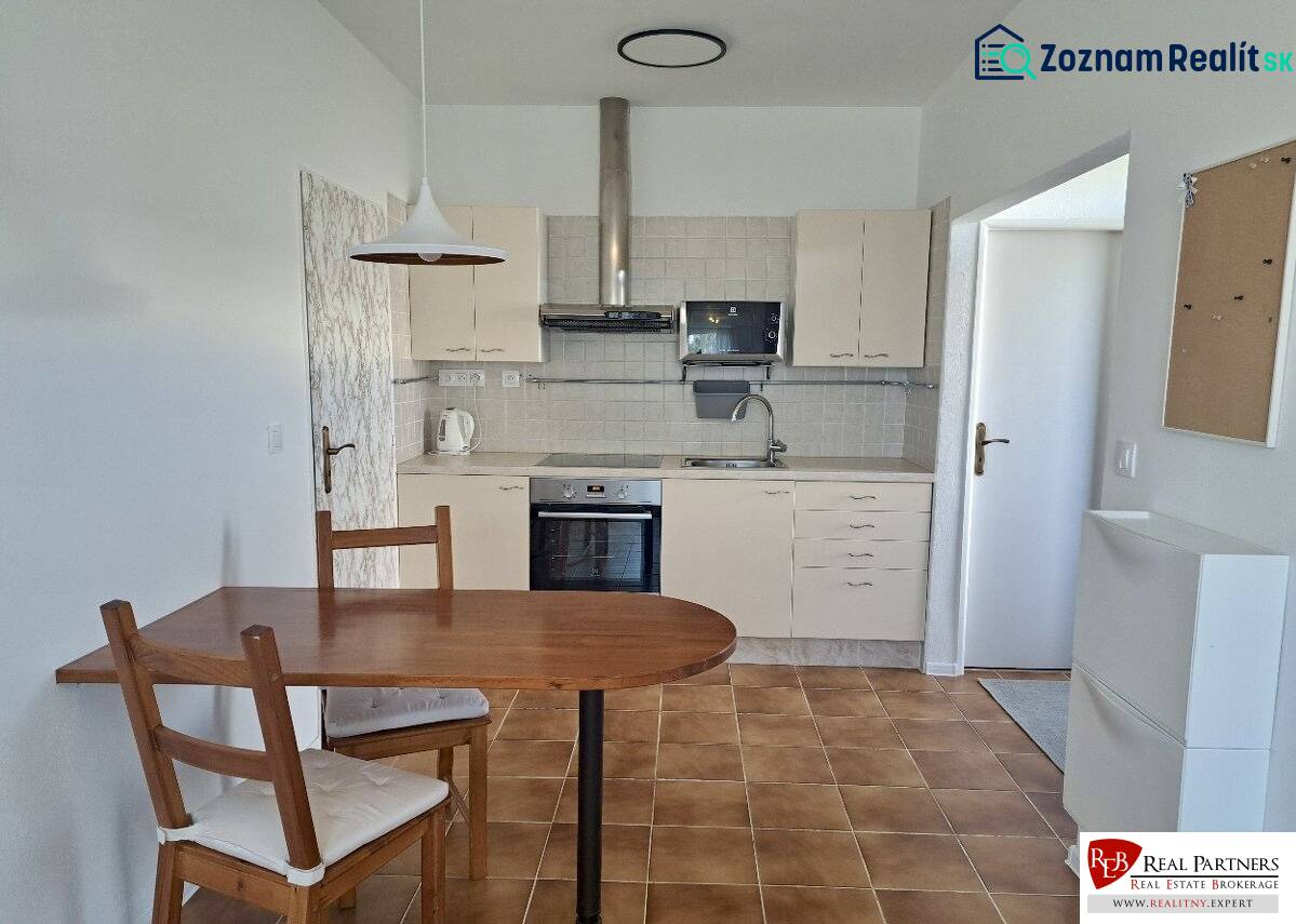 A kitchen in a 3-room apartment with a ceramic floor, a table, and chairs.