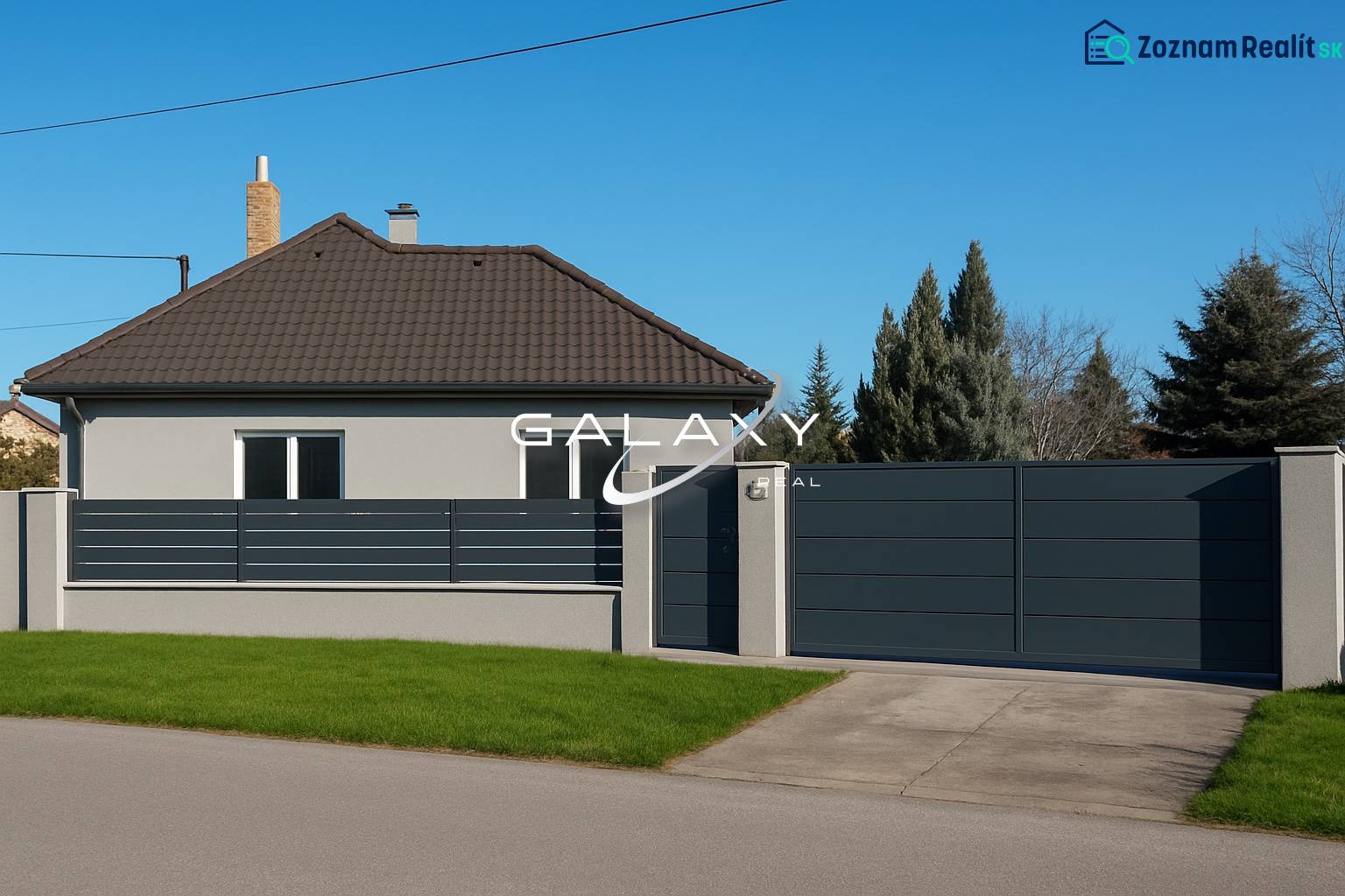 A family house in Horné Saliby with a flat roof, a fence, and a landscaped lawn.