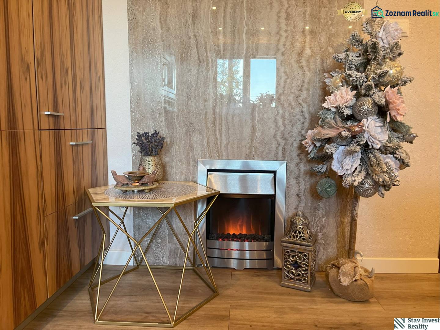 Decoration with an electric fireplace and a table with a vase in a 2-room apartment.