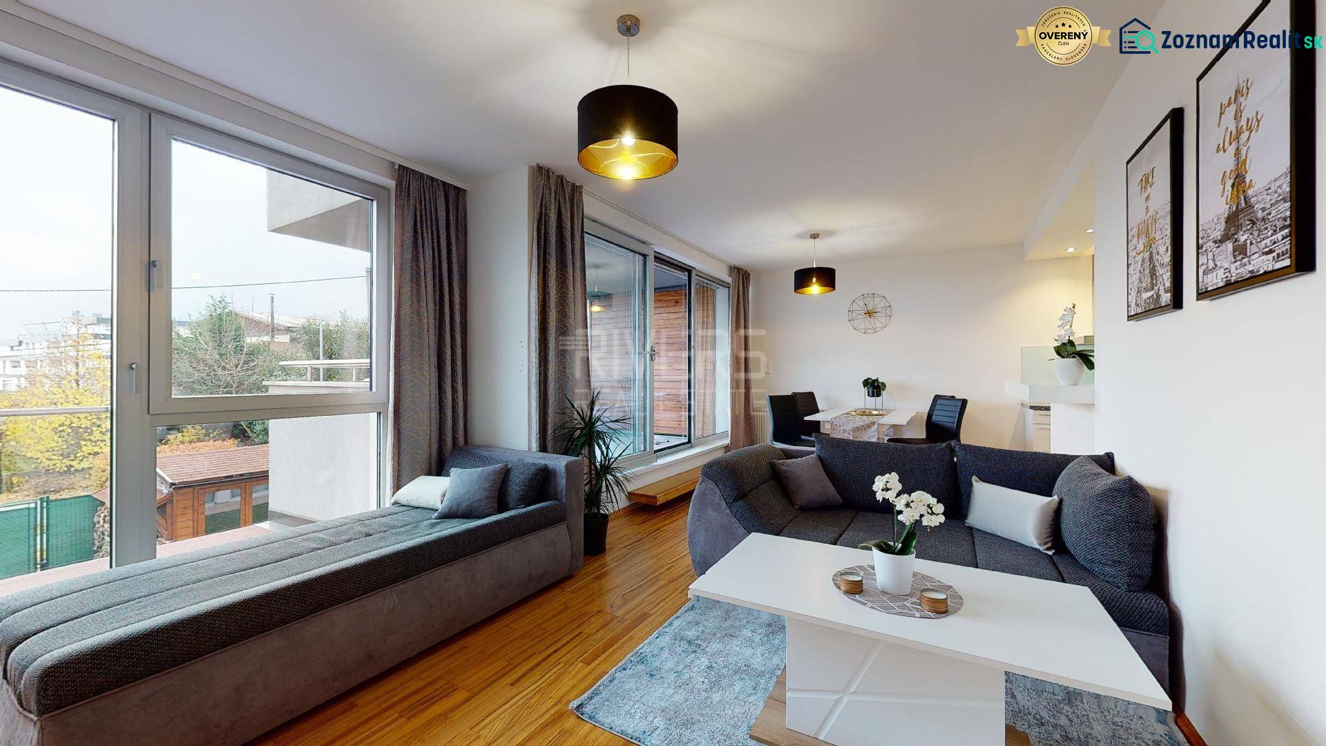 Living room in a two-room apartment with a wooden decor floor and a comfortable sofa.
