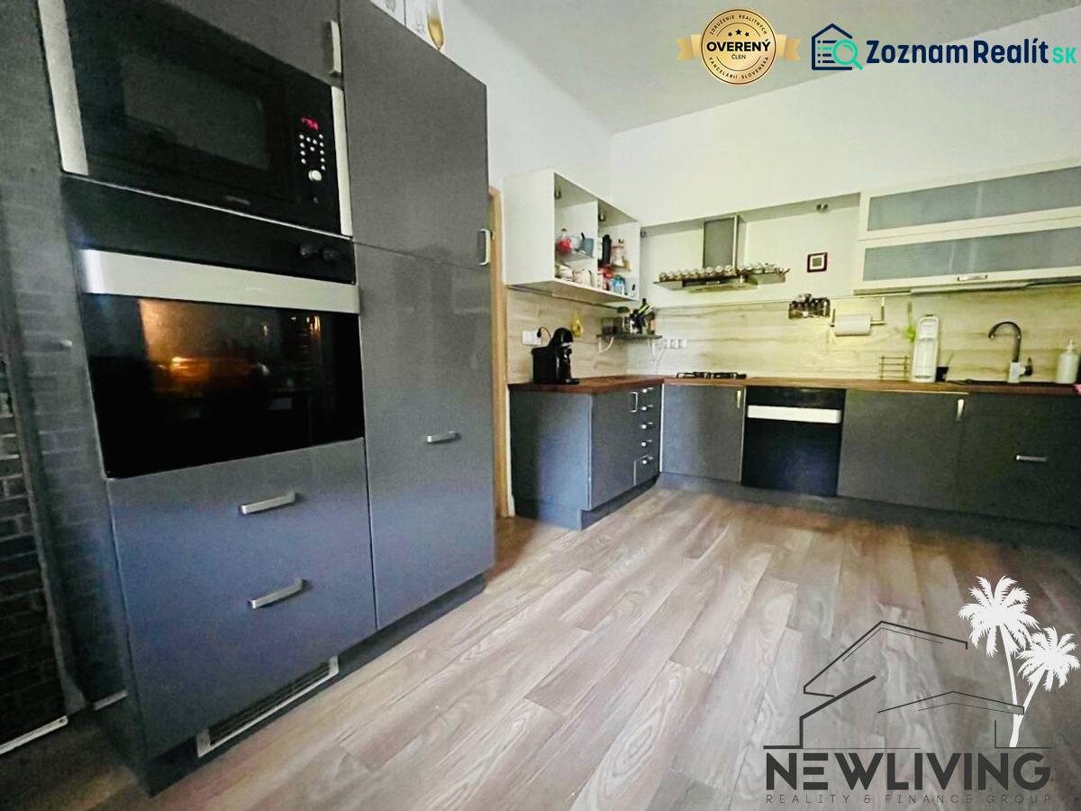 A kitchen in a 3-room apartment with a wooden decor floor and modern equipment.