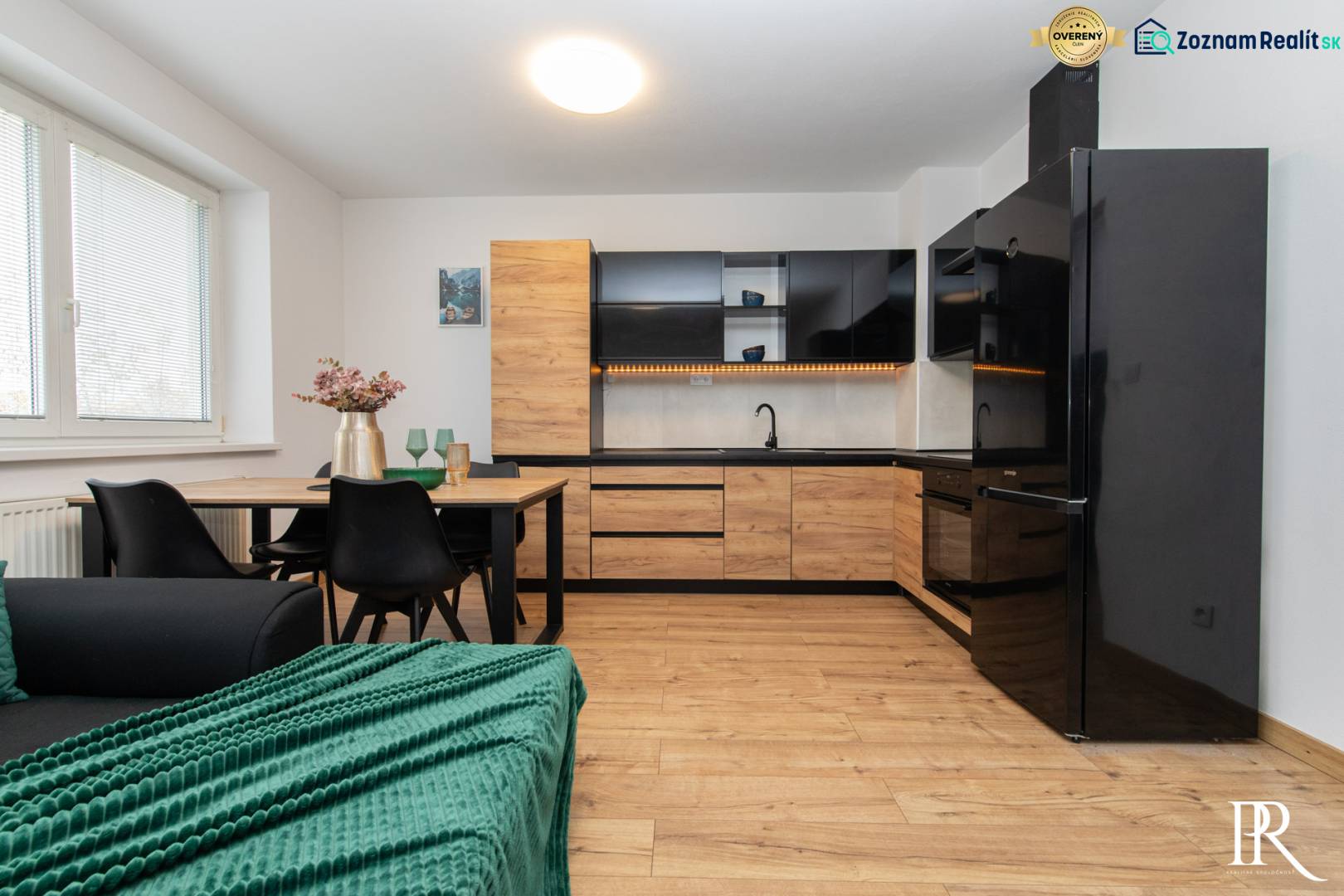 A kitchen in a 2-room apartment with a wooden decor floor and a dining table.