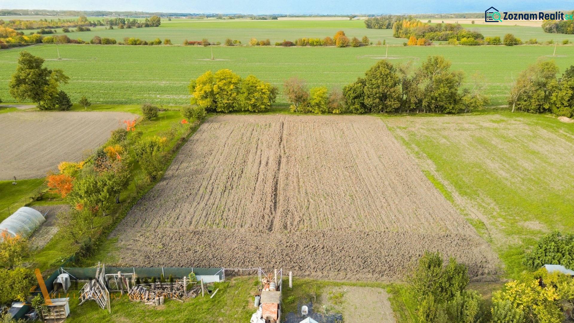 Extensive arable lands in Blahová surrounded by greenery and trees for living.