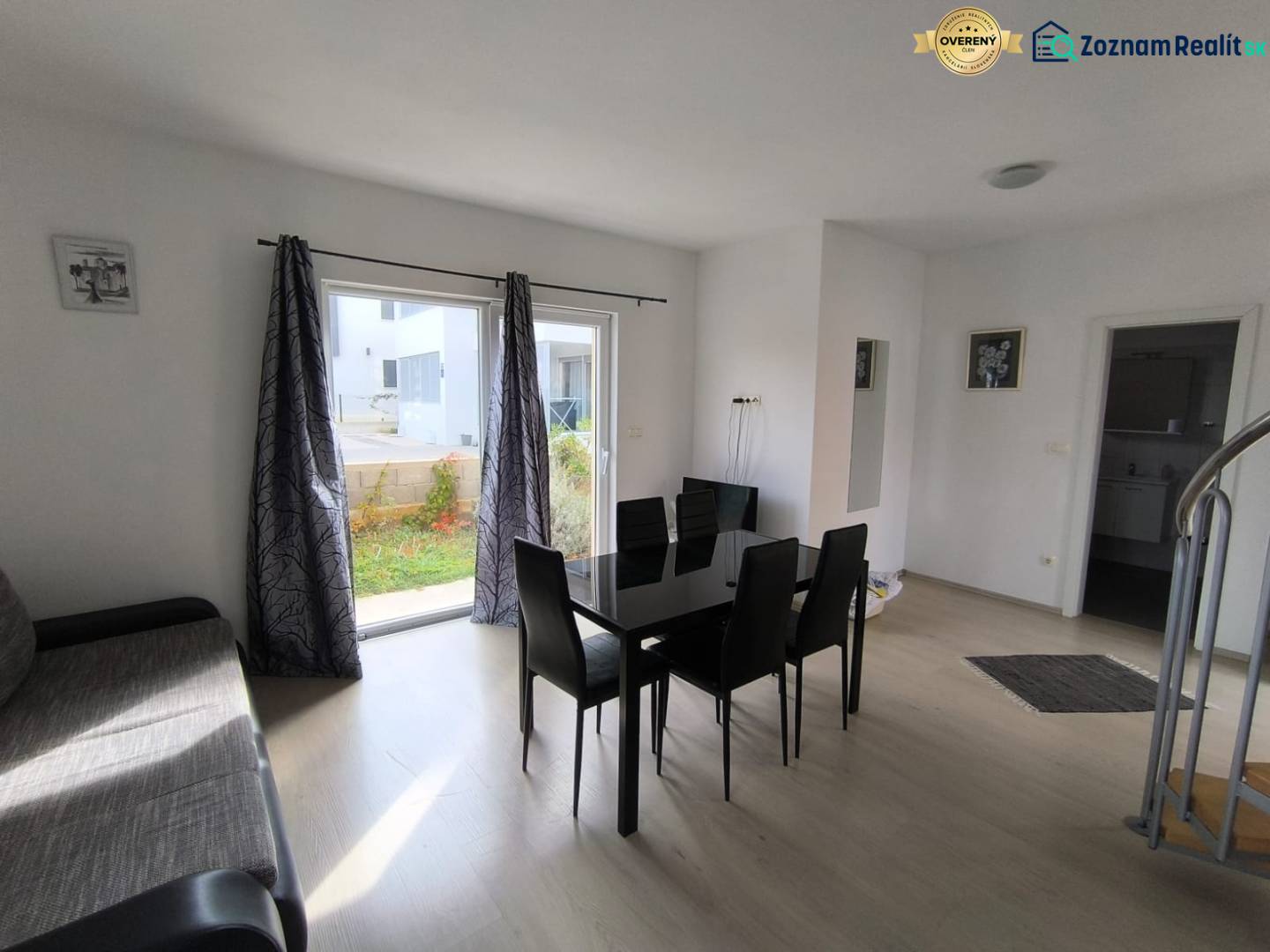 Living room with a black dining table and a wooden decor floor in a 3-room apartment.