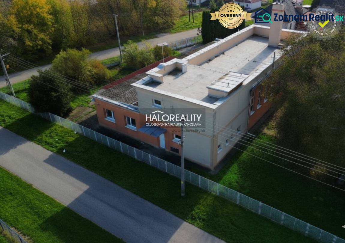 The exterior of commercial premises in Čakajovce, surrounded by greenery and fencing.