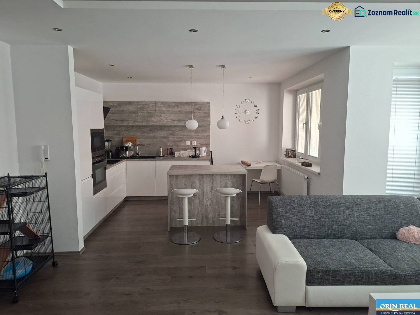 Living room with kitchen in a two-room apartment with a wooden decor floor.
