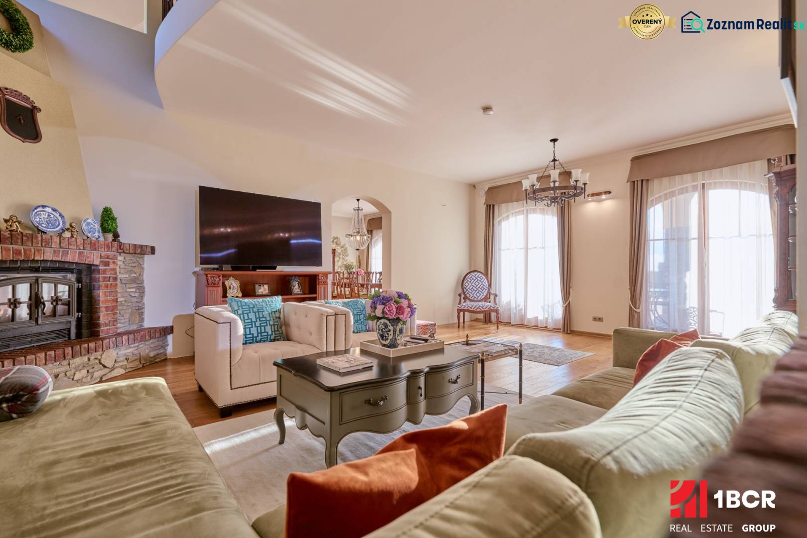 A spacious living room in the villa with comfortable seating, a television, and a tiled stove.