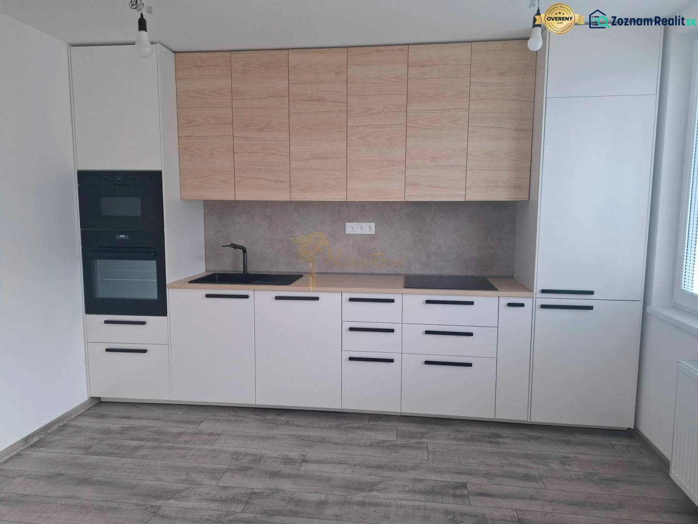 A kitchen in a 3-room apartment with a wooden decor floor and built-in appliances.