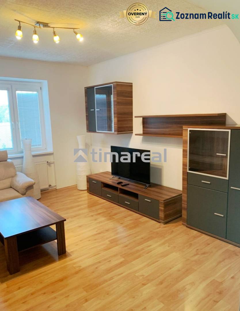 Living room in a two-room apartment with a wooden decor floor and wooden furniture.