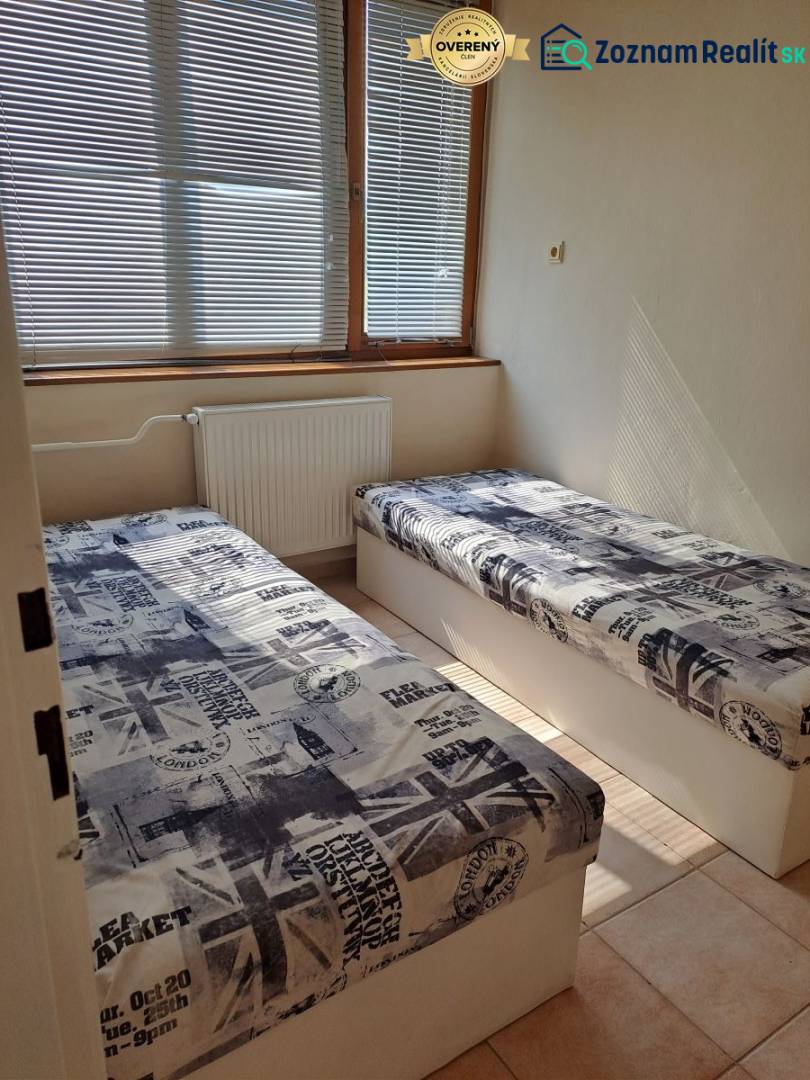 A room with two beds and blinds in a studio apartment, decor with English motifs.