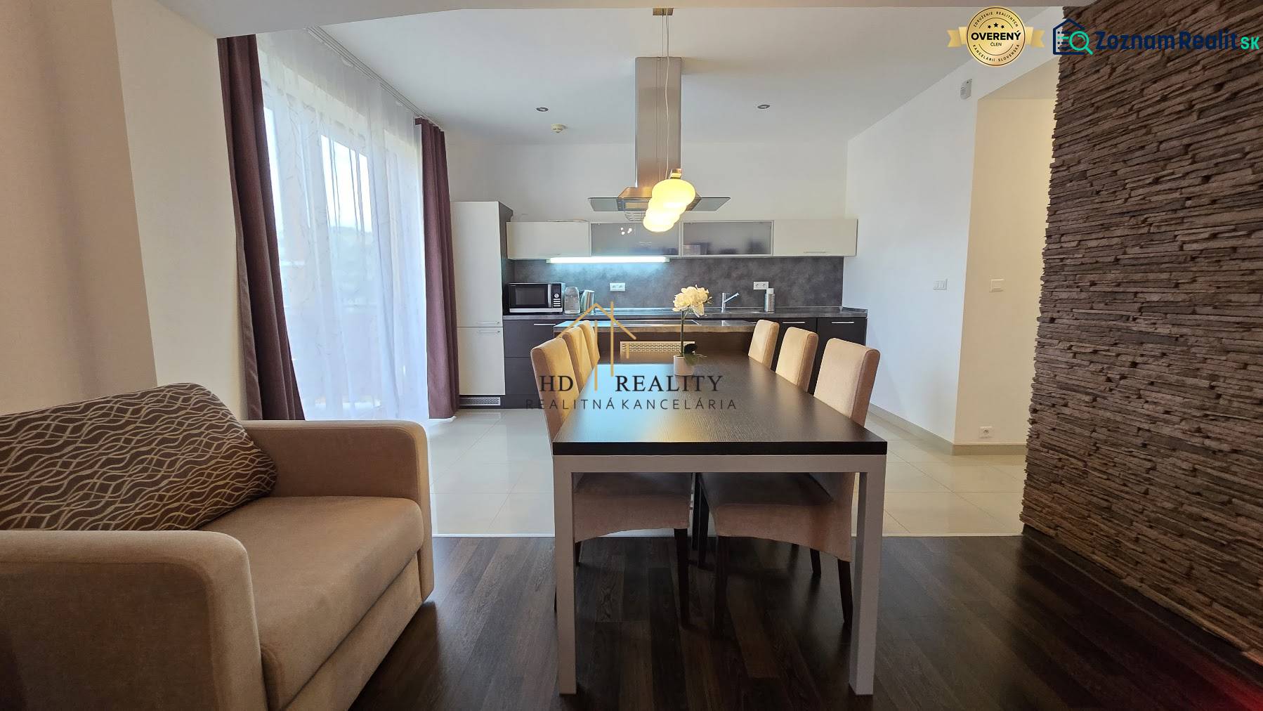 A spacious kitchen with a dining area and a wooden decor floor in a 3-room apartment.
