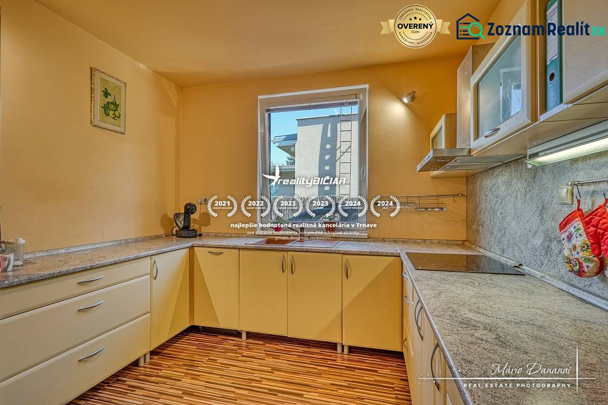 A kitchen in a family house with a window and a floor with a wooden decor.