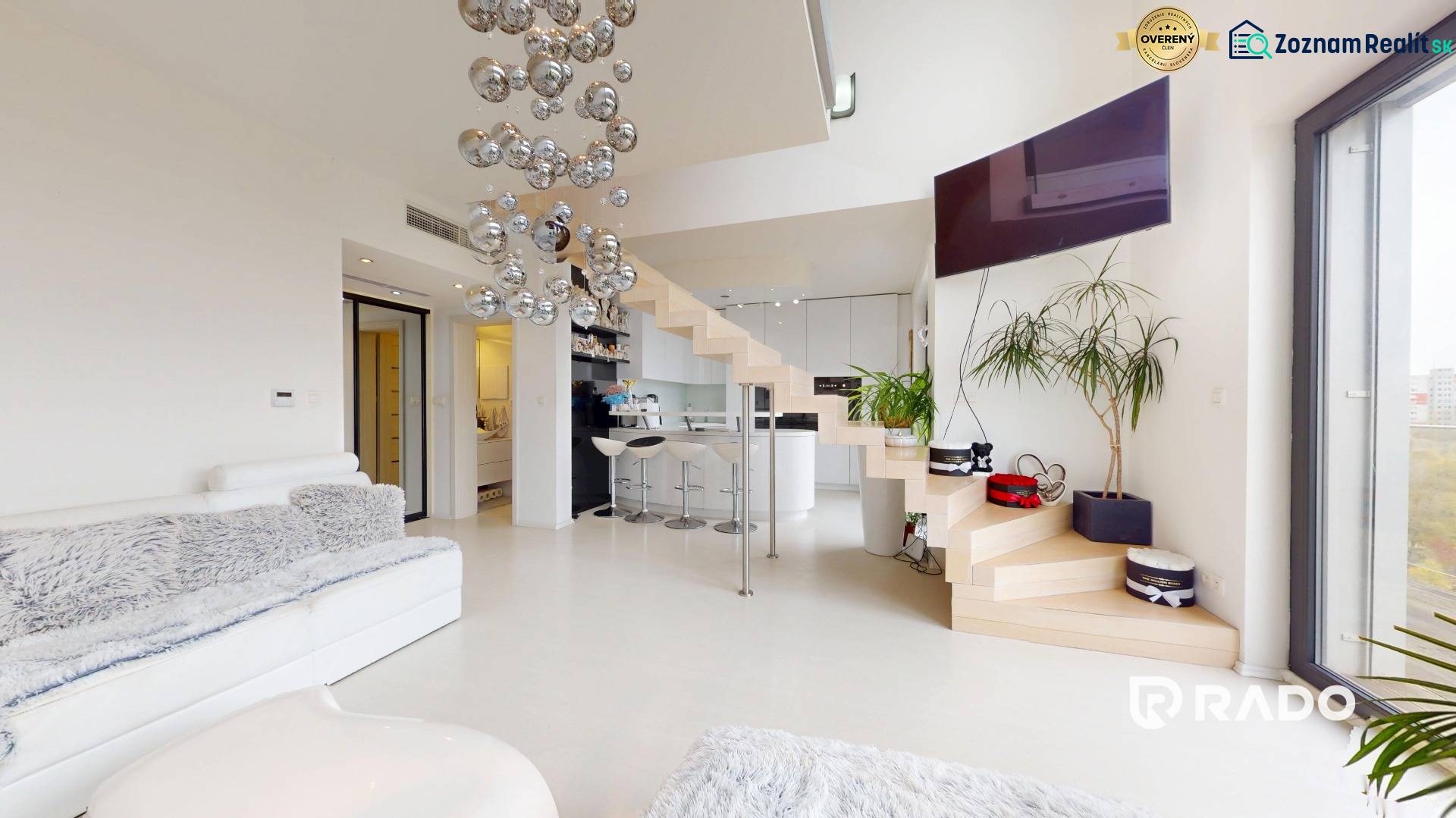 A stylish interior of a 4-room apartment with a white sofa, staircase, and floor with a wooden decor.