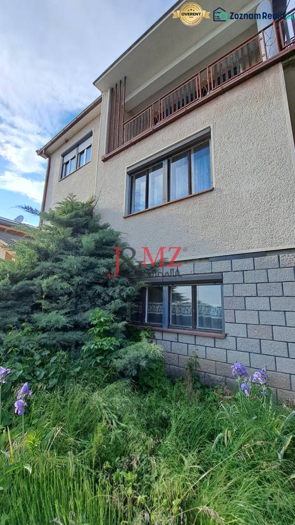 A family house in Hronské Kosihy with a landscaped front garden and a brick facade cladding.