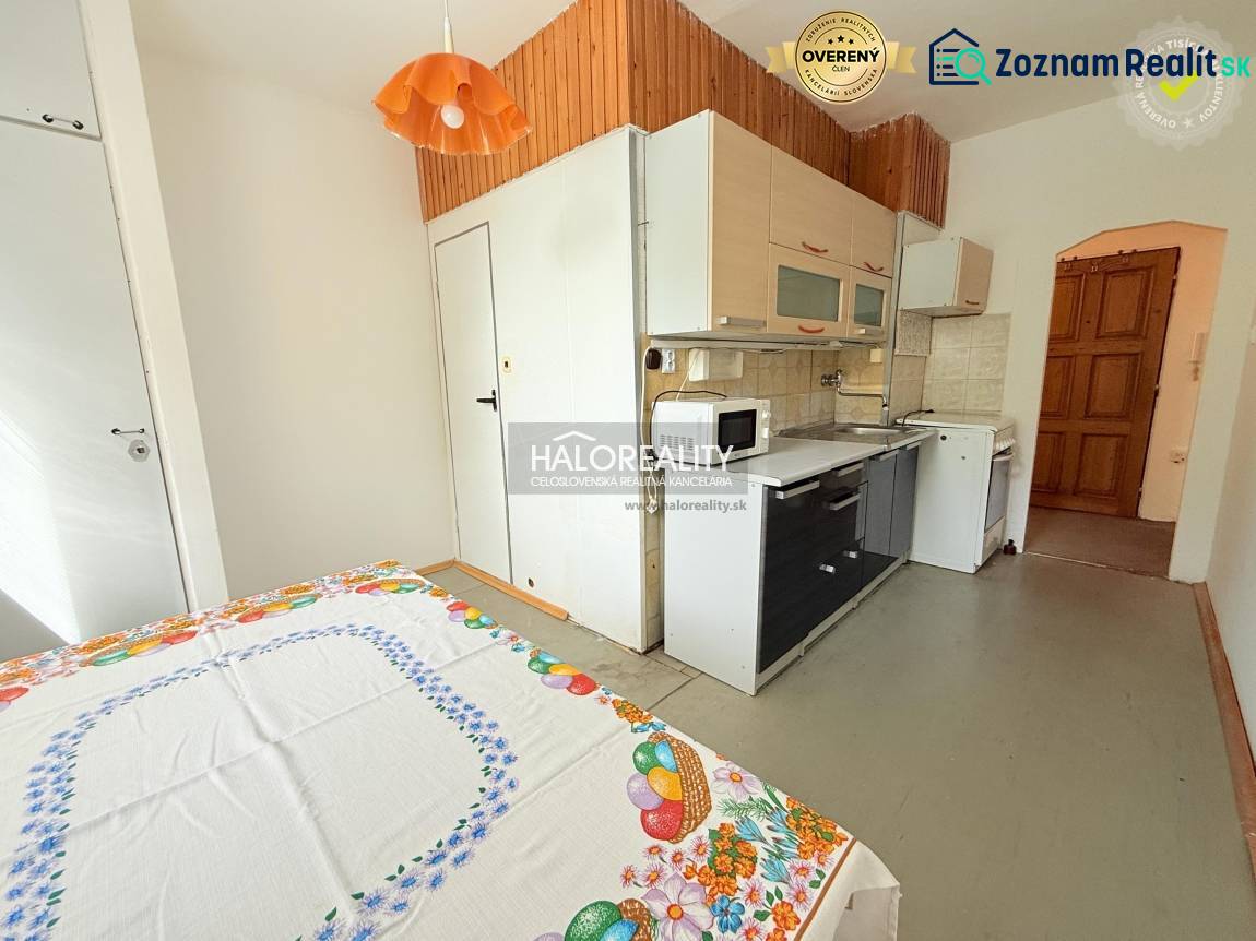 A kitchen in a 2-room apartment with rustic wooden decor and a kitchen unit.