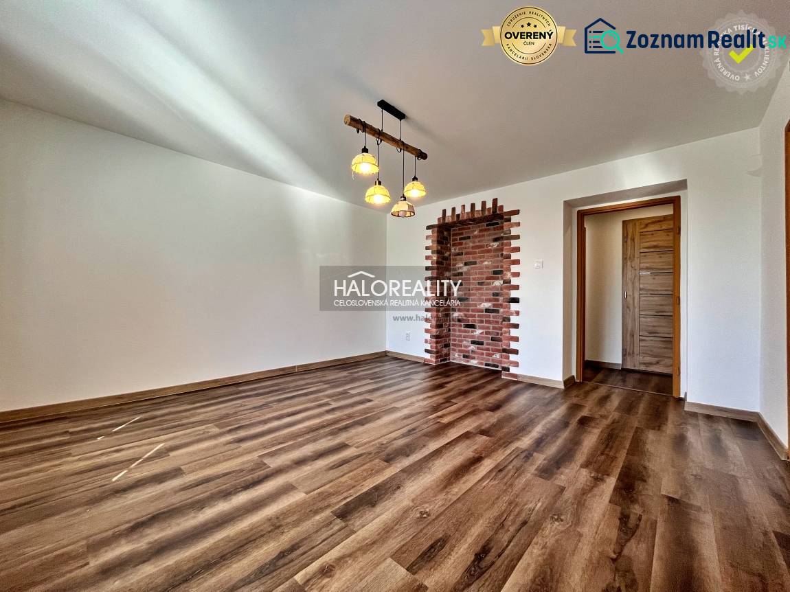 Living room in a three-room apartment with a wooden decor floor and a brick wall.