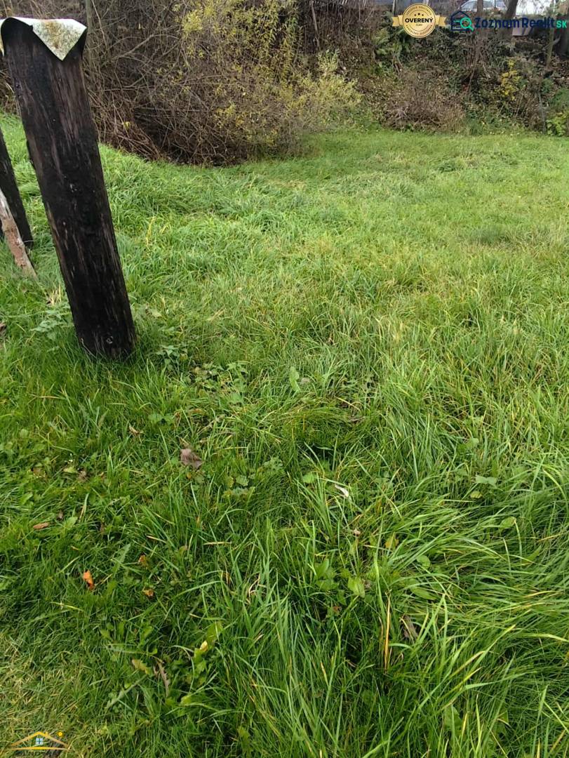 Green lawn and wooden posts on a property in Oščadnica, ideal for living.