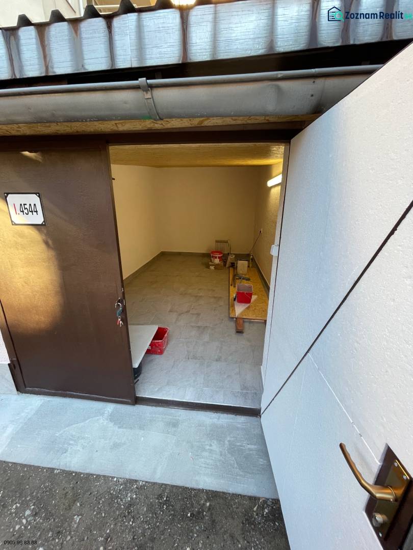 Interior of a garage with open doors, wooden decor flooring, storage space.