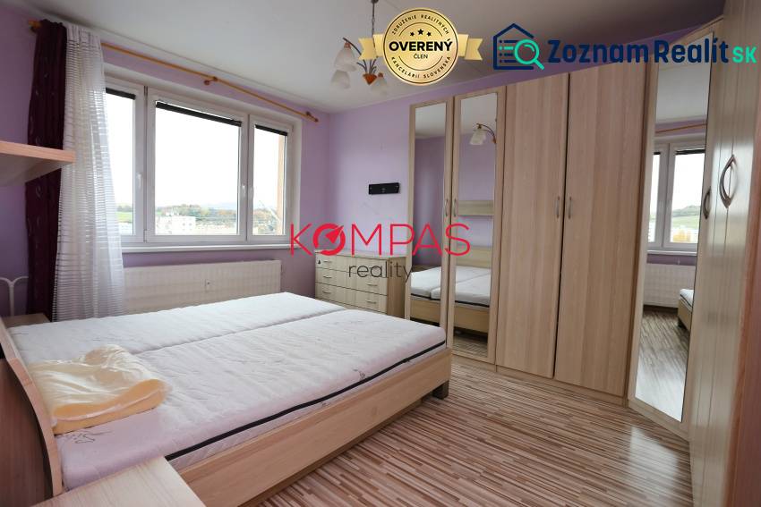 A bright bedroom with wood-patterned flooring in a 3-room apartment.