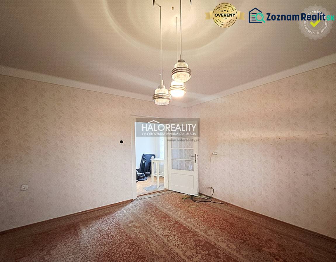 A room in a family house with carpet flooring and pendant lighting.