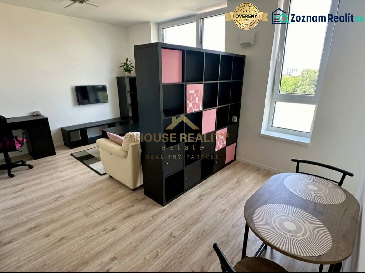 Living room in a 2-room apartment with a shelving wall and a floor with a wood decor.