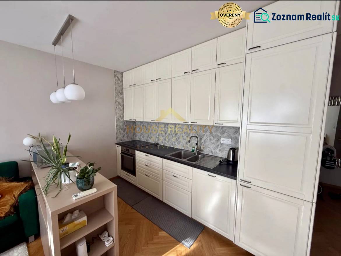 A kitchen in a 3-room apartment with white cabinets and a wooden decor floor.