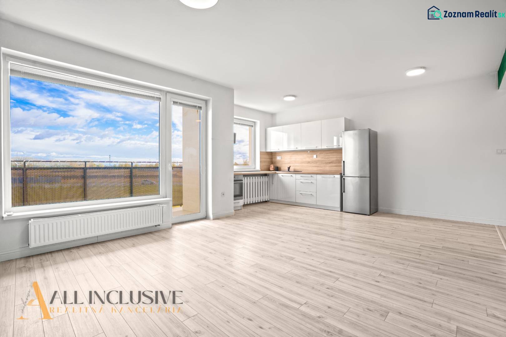 A bright interior of a 2-room apartment with a kitchen, a glass wall, and a floor with a wooden decor.