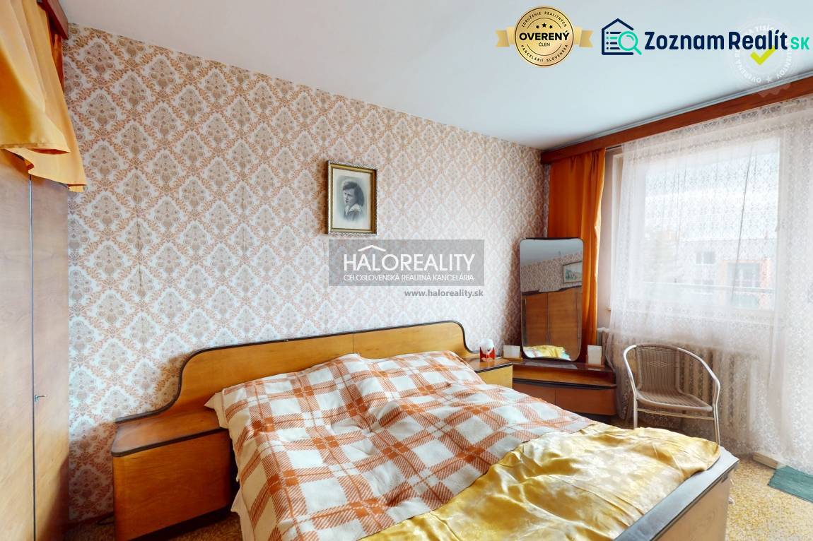 A bedroom in a 3-room apartment with patterned wallpaper and wooden details on the furniture.