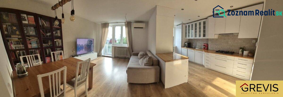 Spacious kitchen with living room in a 3-room apartment. Floor with wood decor, light furniture.